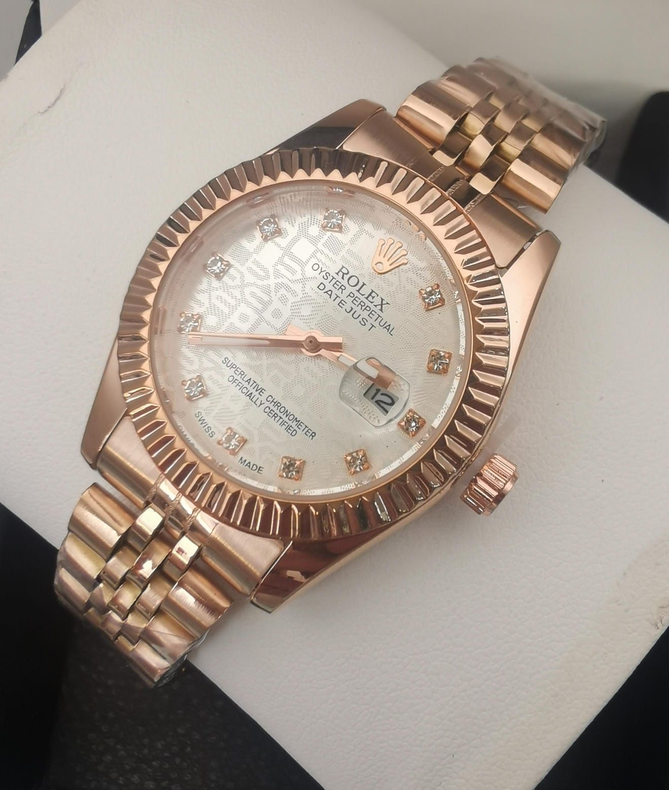 Reloj Rolex de oro rosa con esfera estampada y marcadores de hora de diamantes.