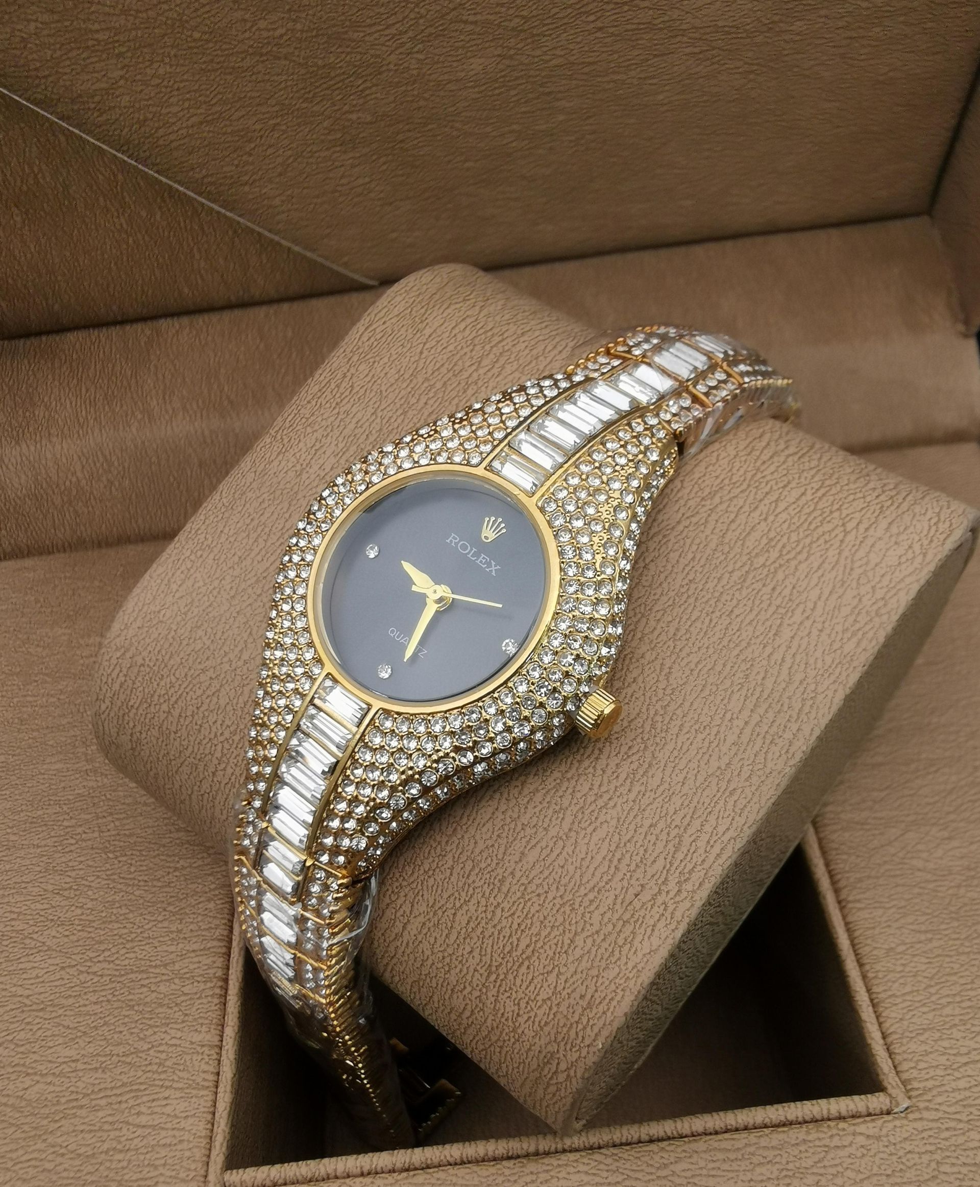 Reloj de pulsera con incrustaciones de oro y joyas sobre una almohada de reloj marrón
