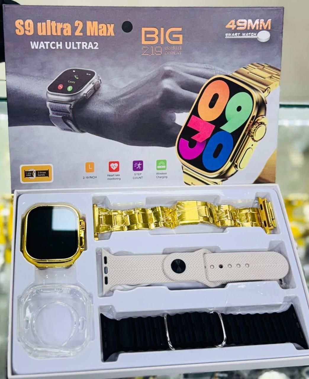 Reloj inteligente en caja con reloj dorado, correas y protector de pantalla. La caja dice