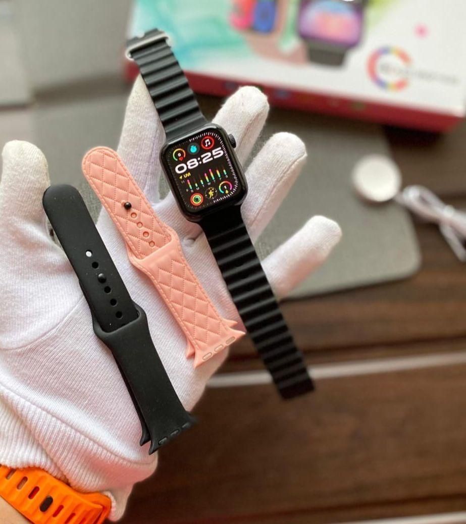 Set de smartwatch T900 Mini: incluye reloj, tres correas (rosa/naranja) y un llavero, en caja.