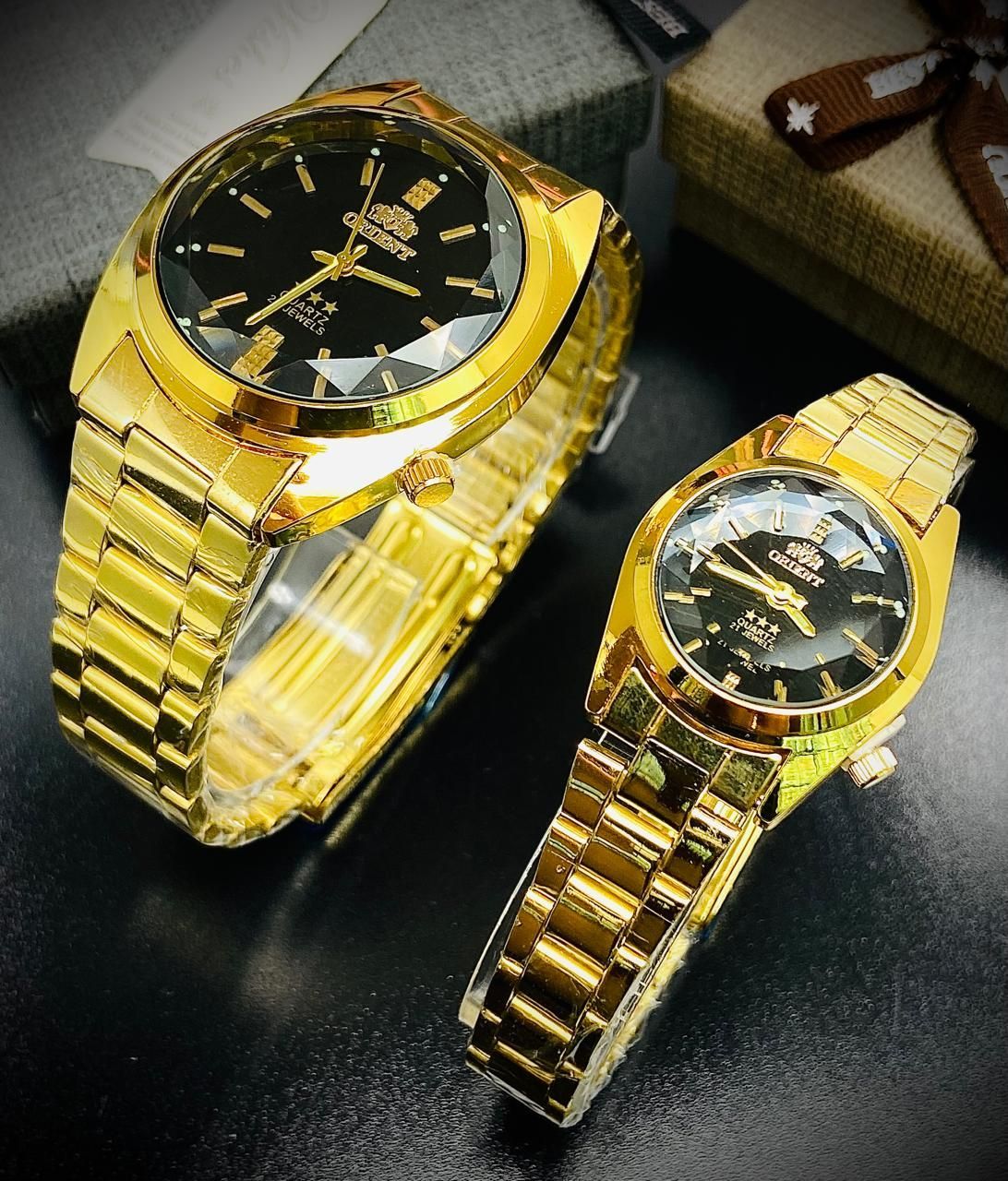 Dos relojes Orient dorados con esferas negras.