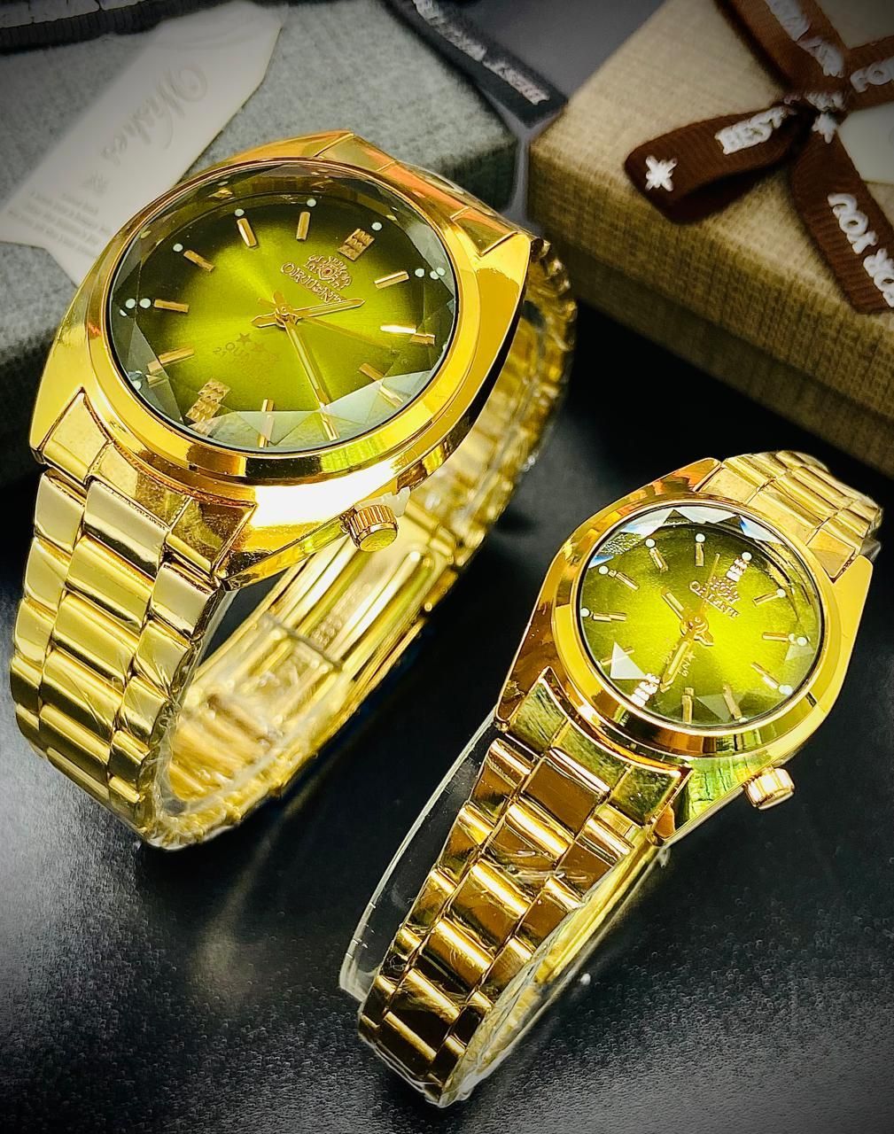 Dos relojes Orient dorados con esferas negras.