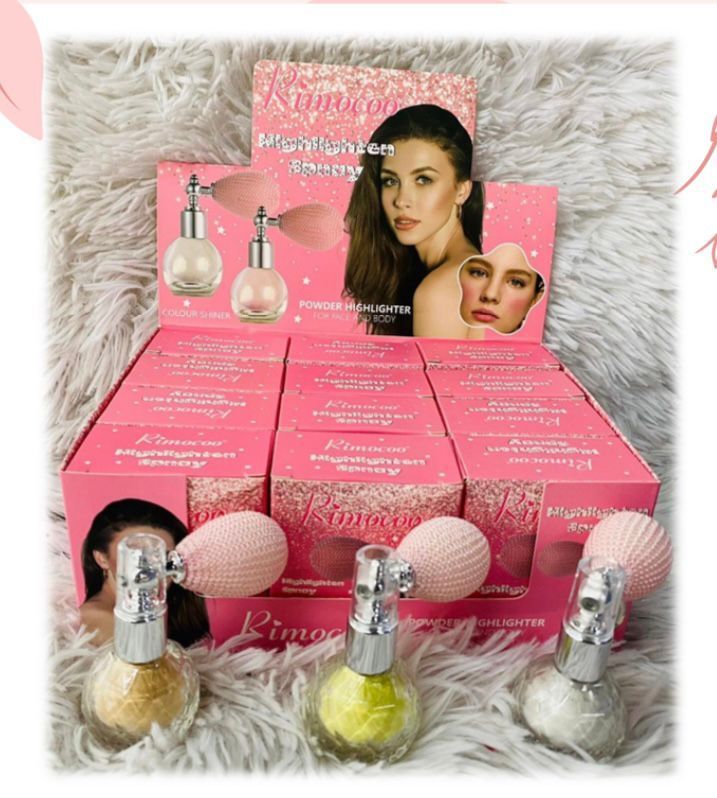 Botellas de polvo cosmético de color rosa con borla, exhibidas en una caja de tienda
