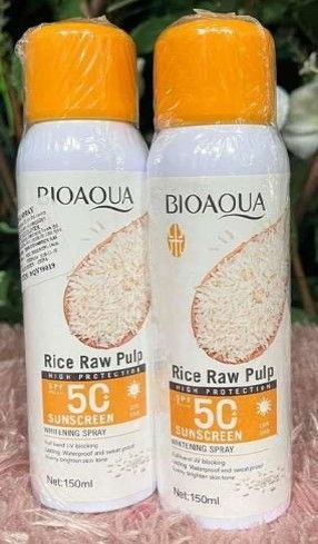 Dos botellas en spray de protector solar BIOAQUA de pulpa cruda de arroz con FPS 50, empaque blanco y naranja.