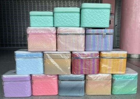 Una colección de cajas de almacenamiento de plástico tejido en varios colores apiladas una encima de otra.