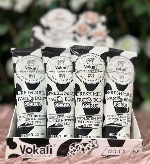 Una exhibición de tubos de exfoliante facial y corporal Vokali Fresh Milk en empaque blanco y negro.