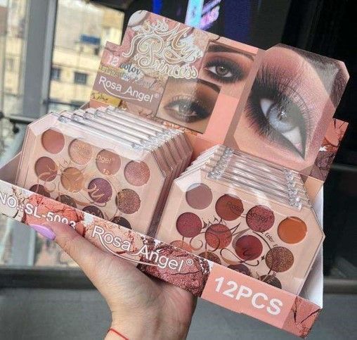 Mujer sosteniendo una caja de paletas de sombras de ojos