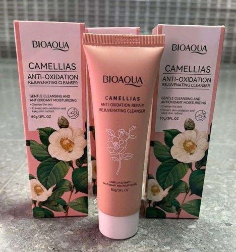 Tres tubos de limpiador rejuvenecedor antioxidante BIOAQUA Camellias sobre un fondo rosa.
