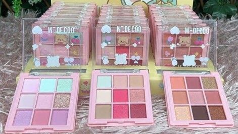 Paletas de sombras de ojos rosas en exhibición, varios tonos, con empaque con temática de osos.