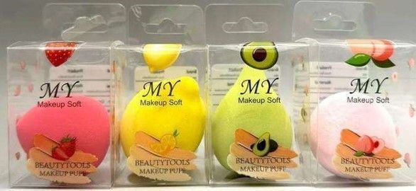Cuatro esponjas de maquillaje en empaque con temática frutal: fresa, limón, aguacate y melocotón.