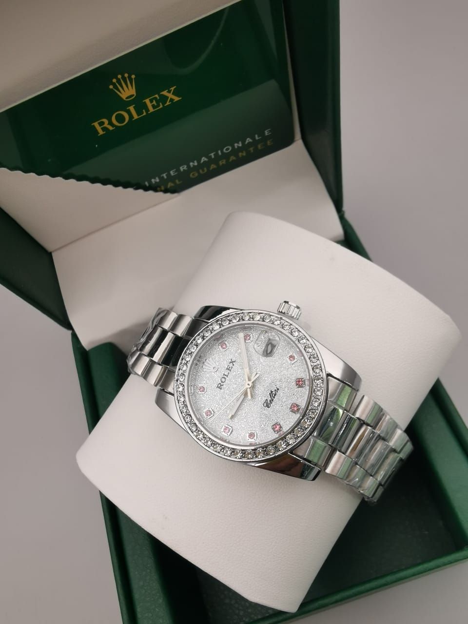 Reloj Rolex en caja con correa bicolor plateada y dorada, bisel y esfera con diamantes.