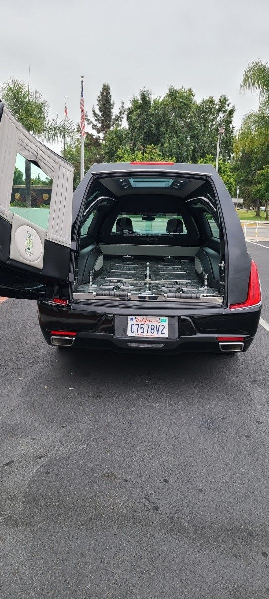 Black SUV with rear hatch open in a parking lot, showing cargo space and folded seats.