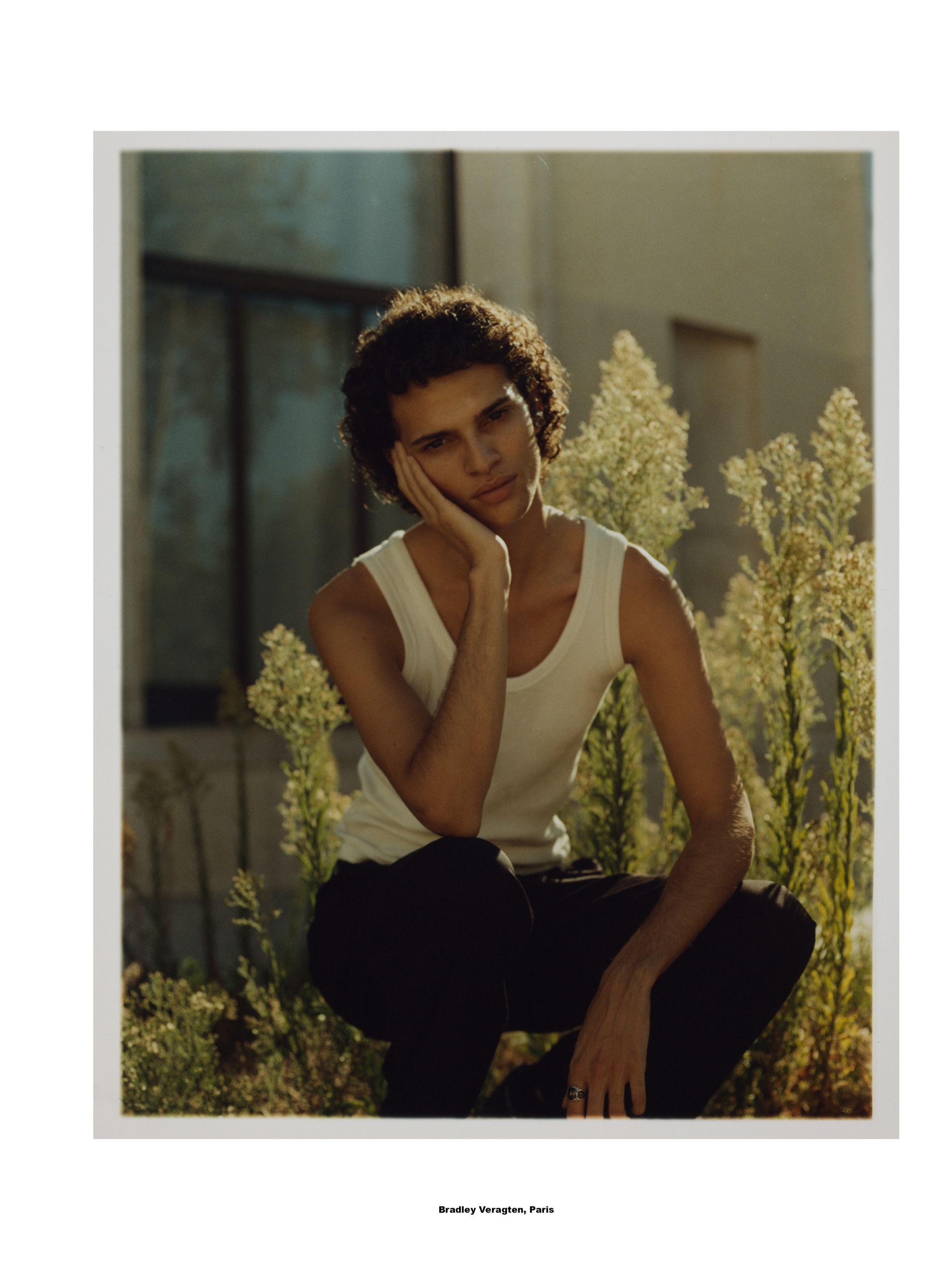 Person in weißem Tanktop posiert im Freien. 