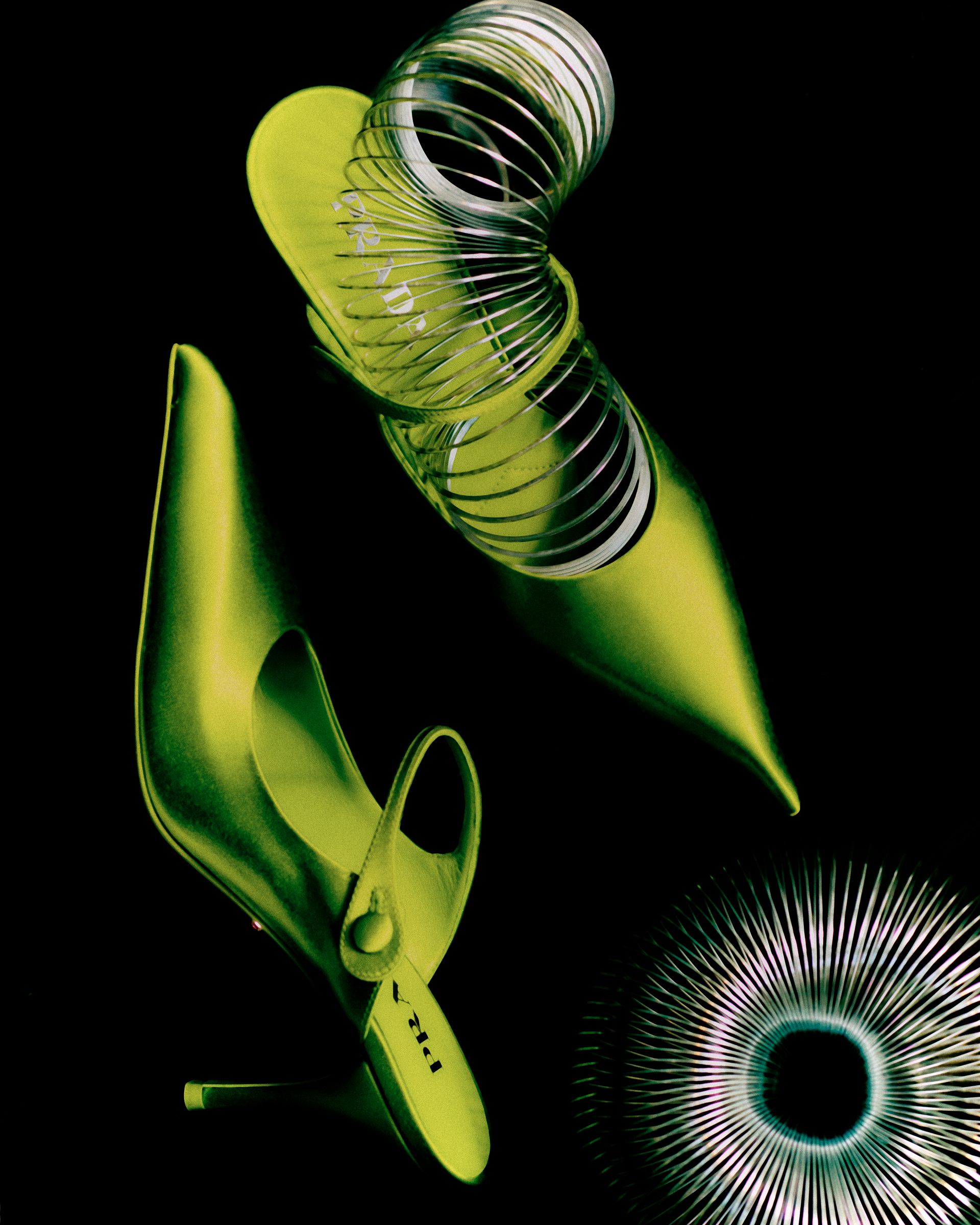Grüne Stöckelschuhe mit spiralförmigen Akzenten auf schwarzem Hintergrund.