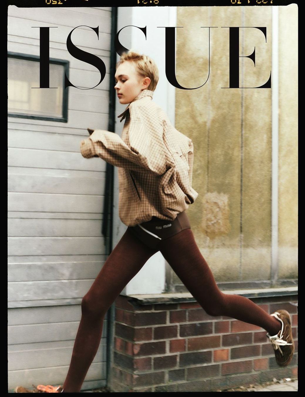 Frau in braunem Outfit läuft draußen, Zeitschriftencover.