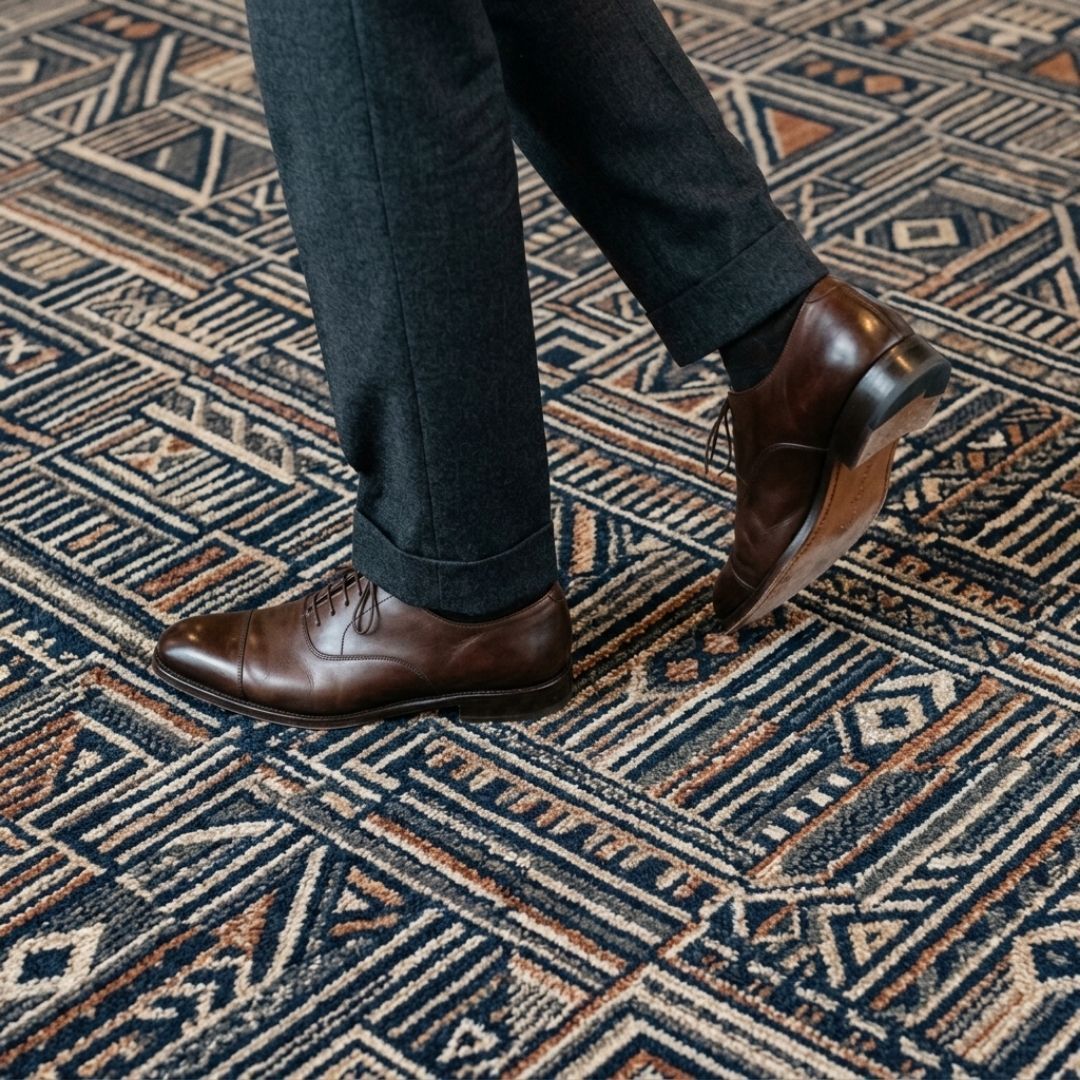Professional shoes walking on clean, well-maintained commercial carpeting.