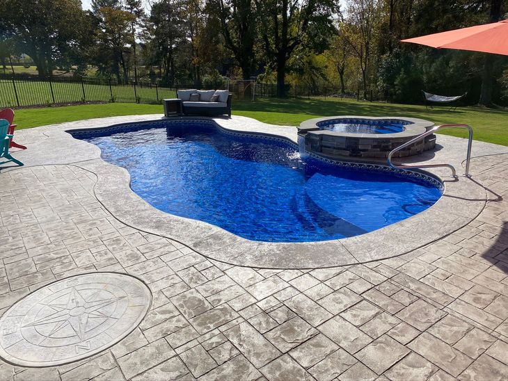 a large swimming pool with a hot tub in the middle