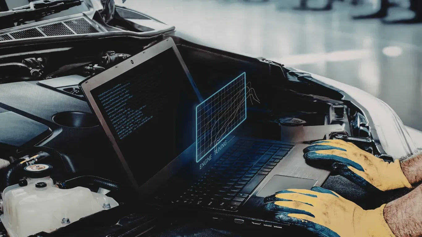Mechanic using laptop for digital engine tuning.
