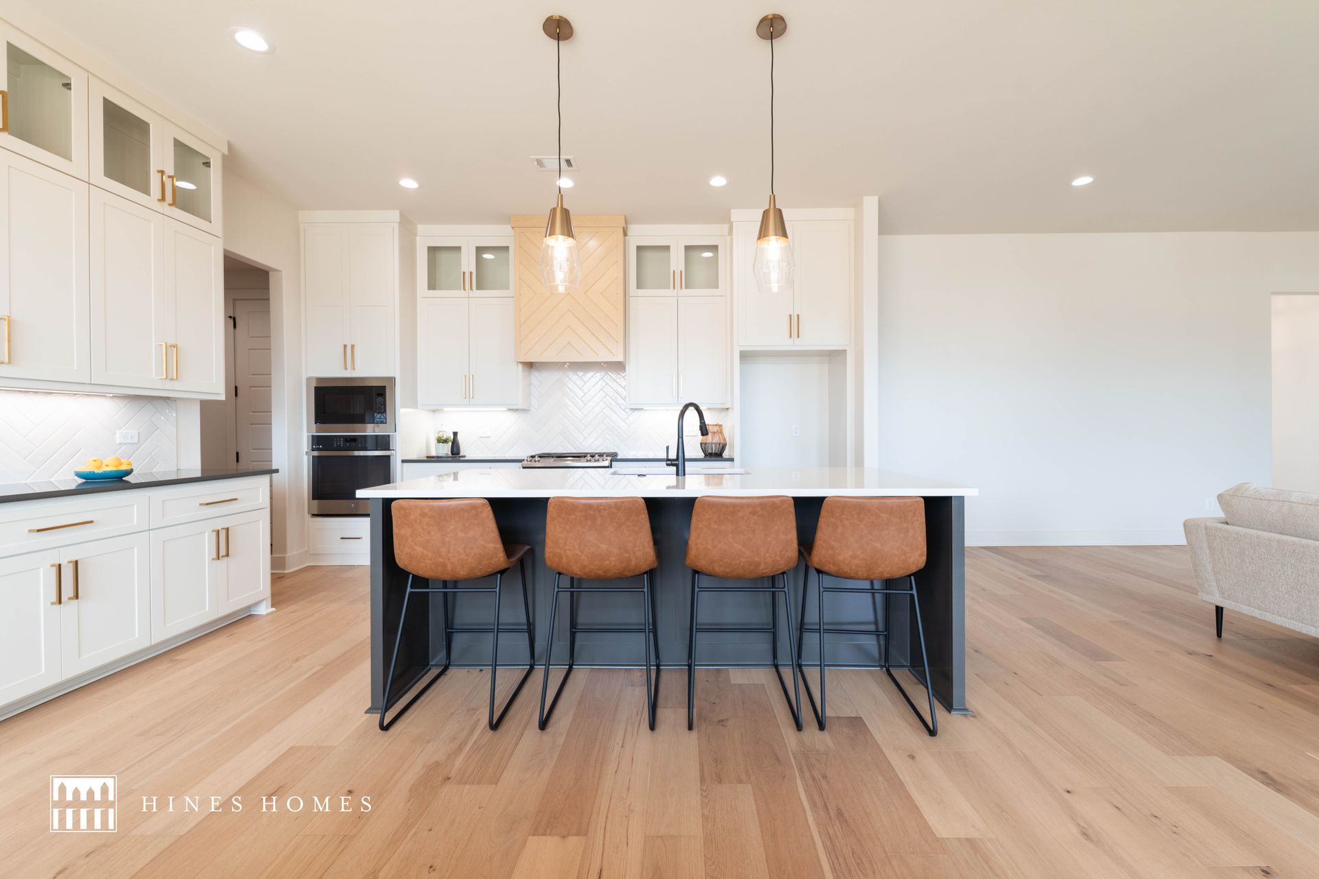 inviting kitchen with an island and open floor plan into the living room. build by hines homes