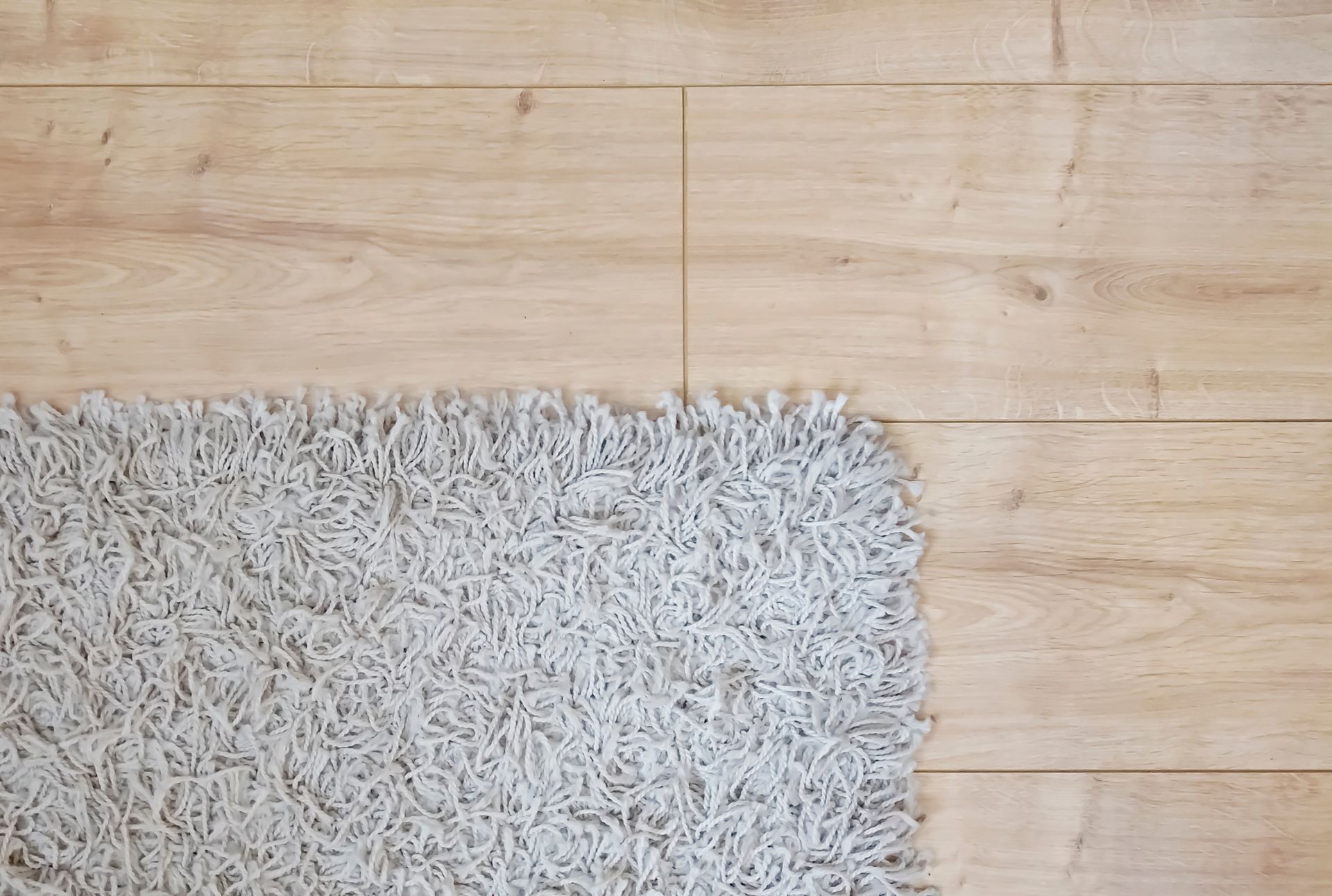 There is a rug on the floor next to a wooden floor.