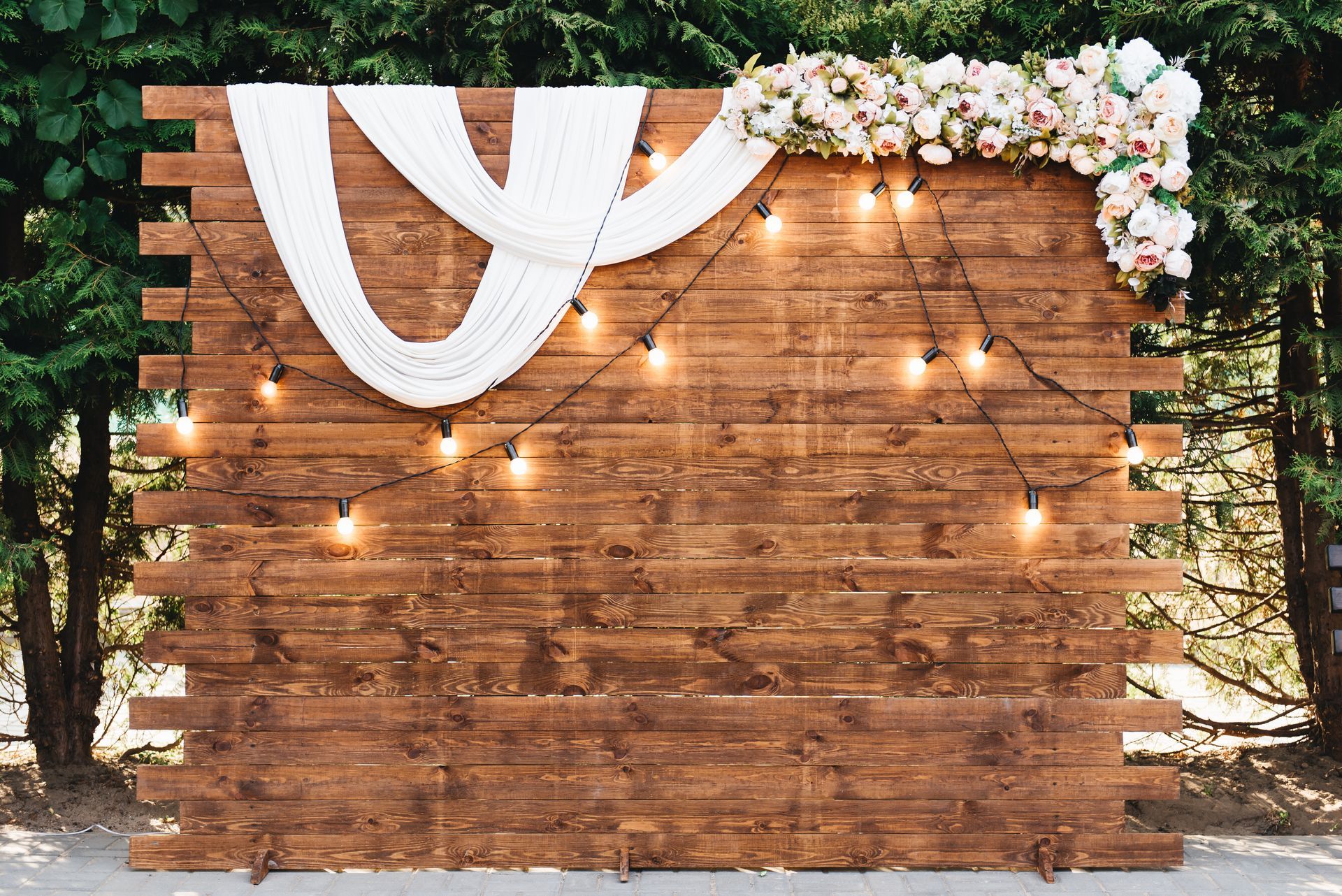 Rustic wooden wedding arch with retro garland decorated with flowers and lights