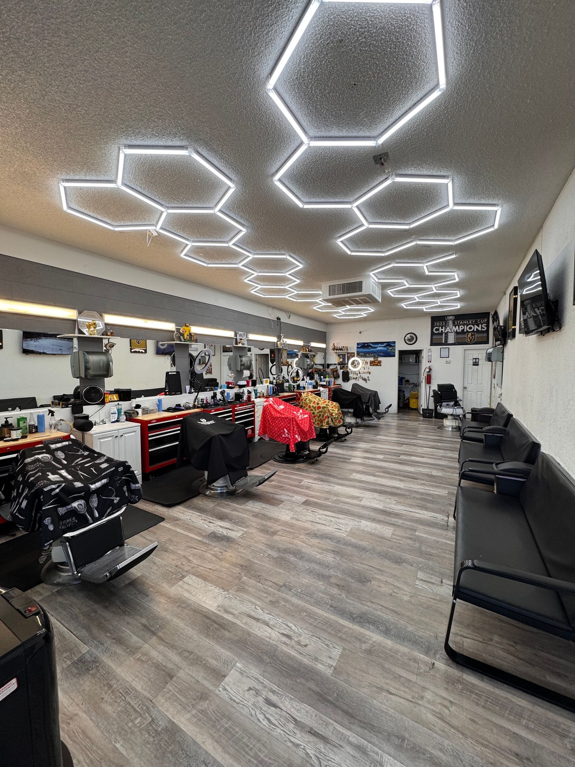 Modern salon interior with geometric LED ceiling lights, black chairs, and retail displays