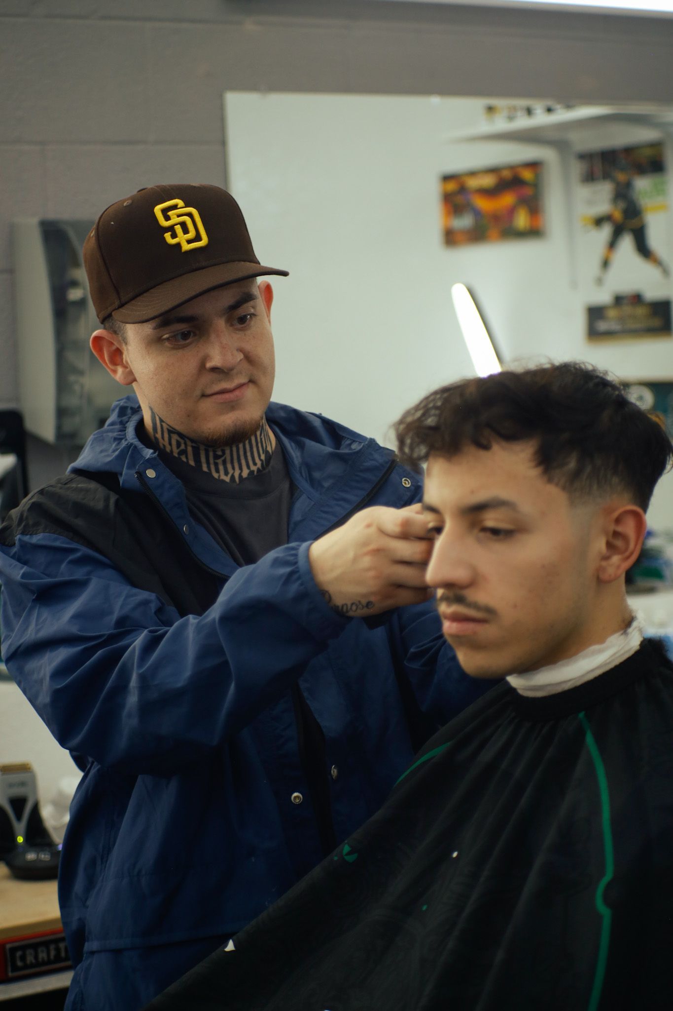 Barber trimming a client’s hair with clippers in a salon