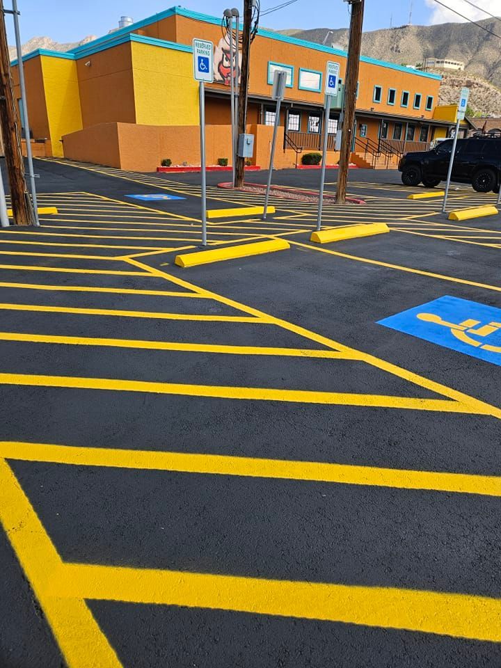 A parking lot with yellow lines and a handicap sign