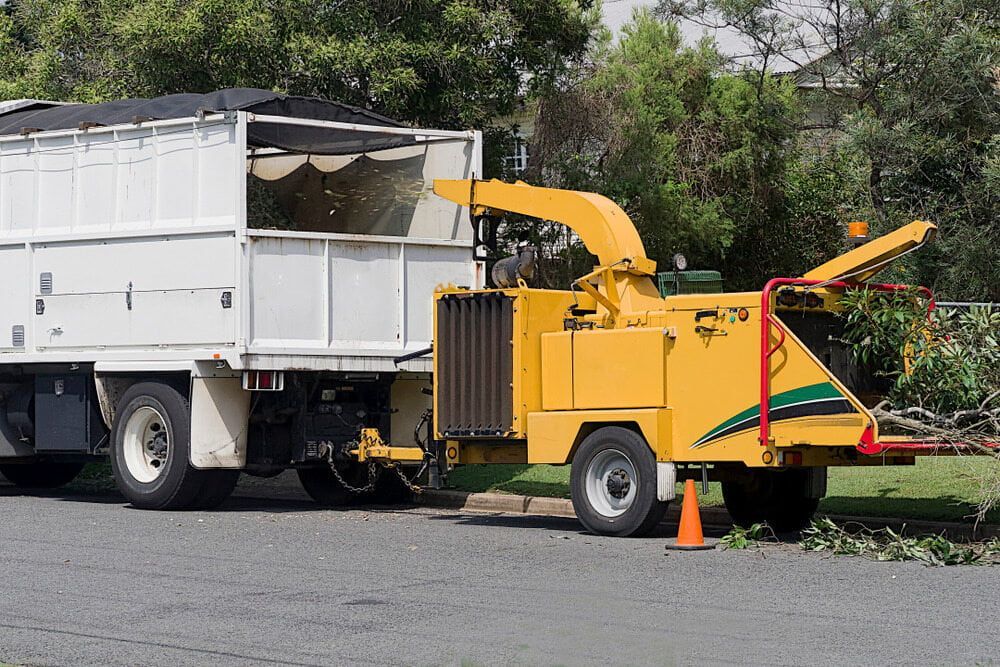 A Yellow Tree Chipper Is Attached to A White Truck — Boyne Island Tree Services in Calliope, QLD