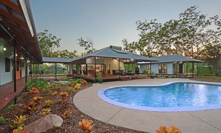 A Large House With a Swimming Pool in Front of It — Darwin Glass in Yarrawonga, NT