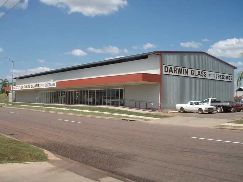 A Darwin Glass Building With Cars Parked in Front of It — Darwin Glass in Yarrawonga, NT