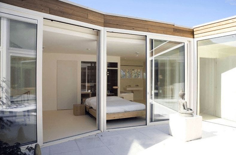 A Bedroom With a Bed and Sliding Glass Doors — Darwin Glass in Yarrawonga, NT