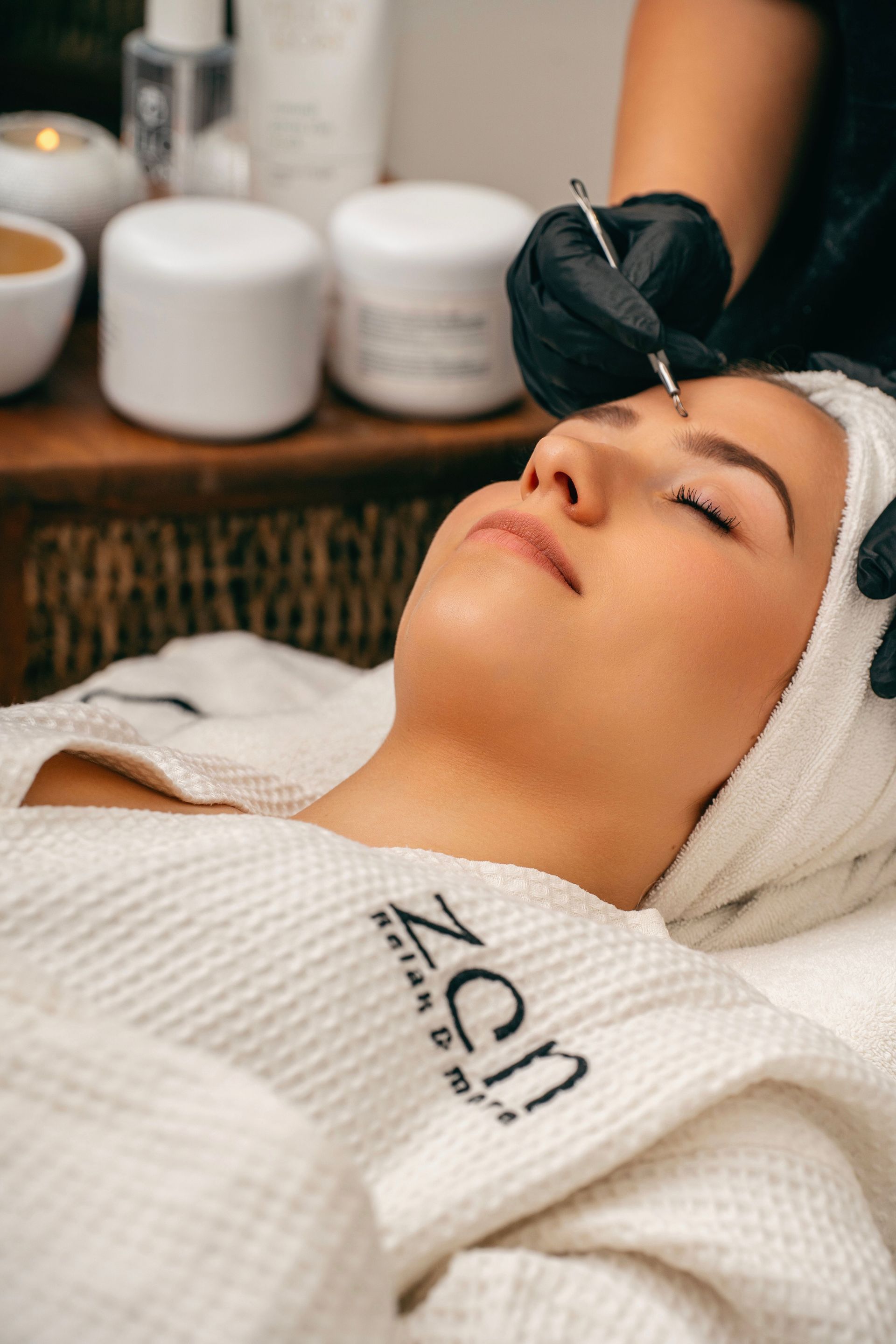 Client relaxing with her eyes closed during a facial treatment