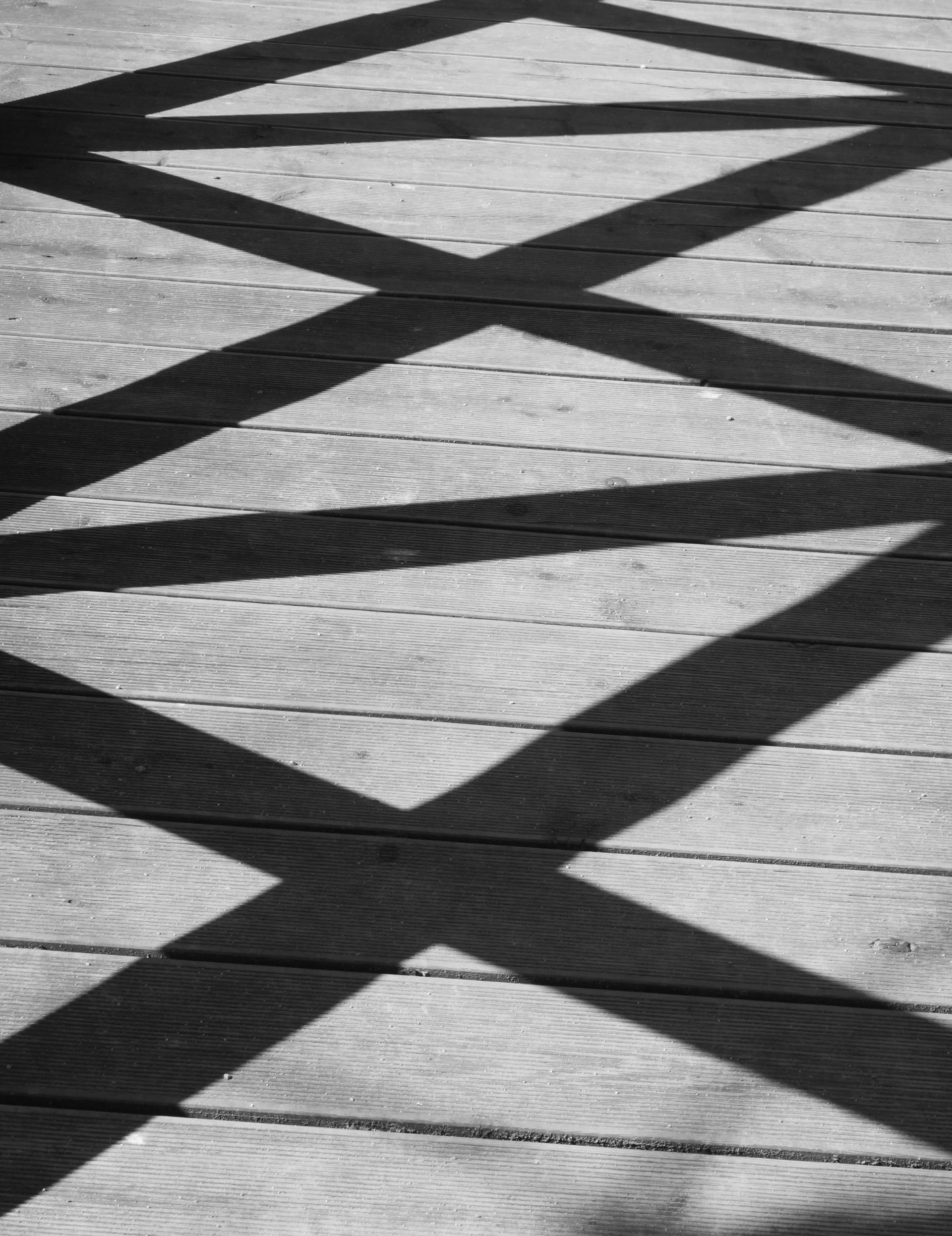 Grey decking boards striped with shadow