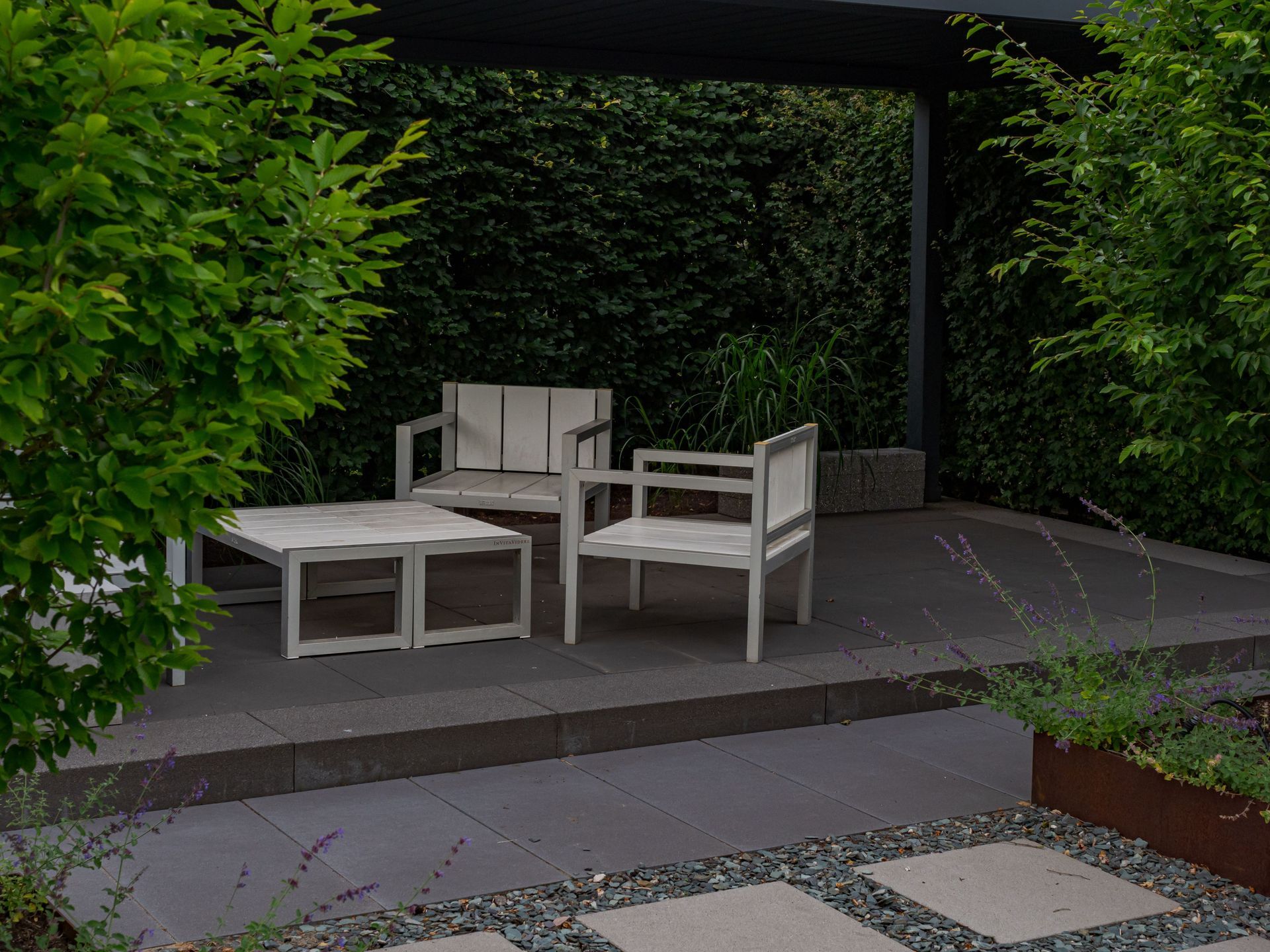 Paved garden patio with outdoor table and chairs