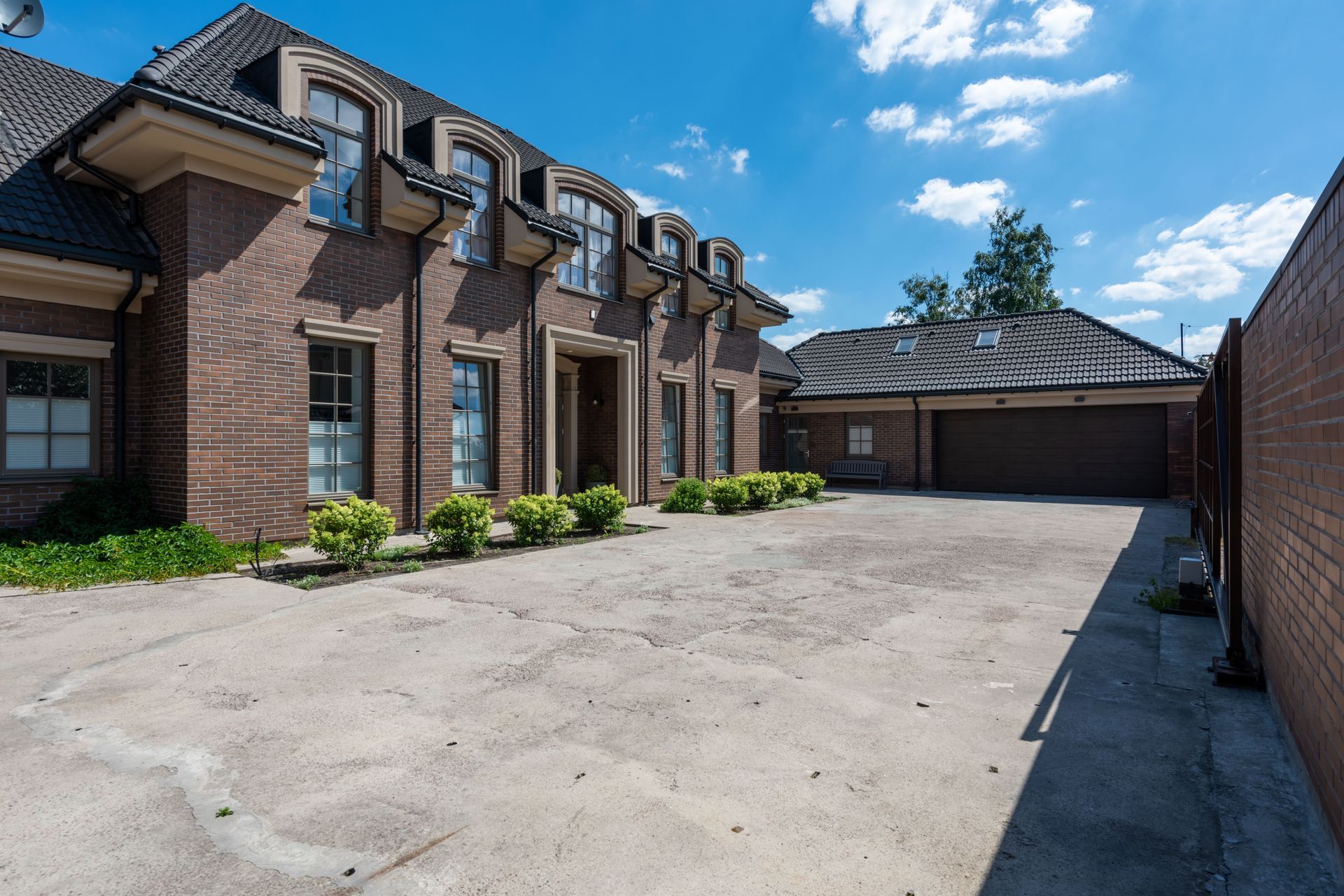 Brick house with a garage and a paved front driveway