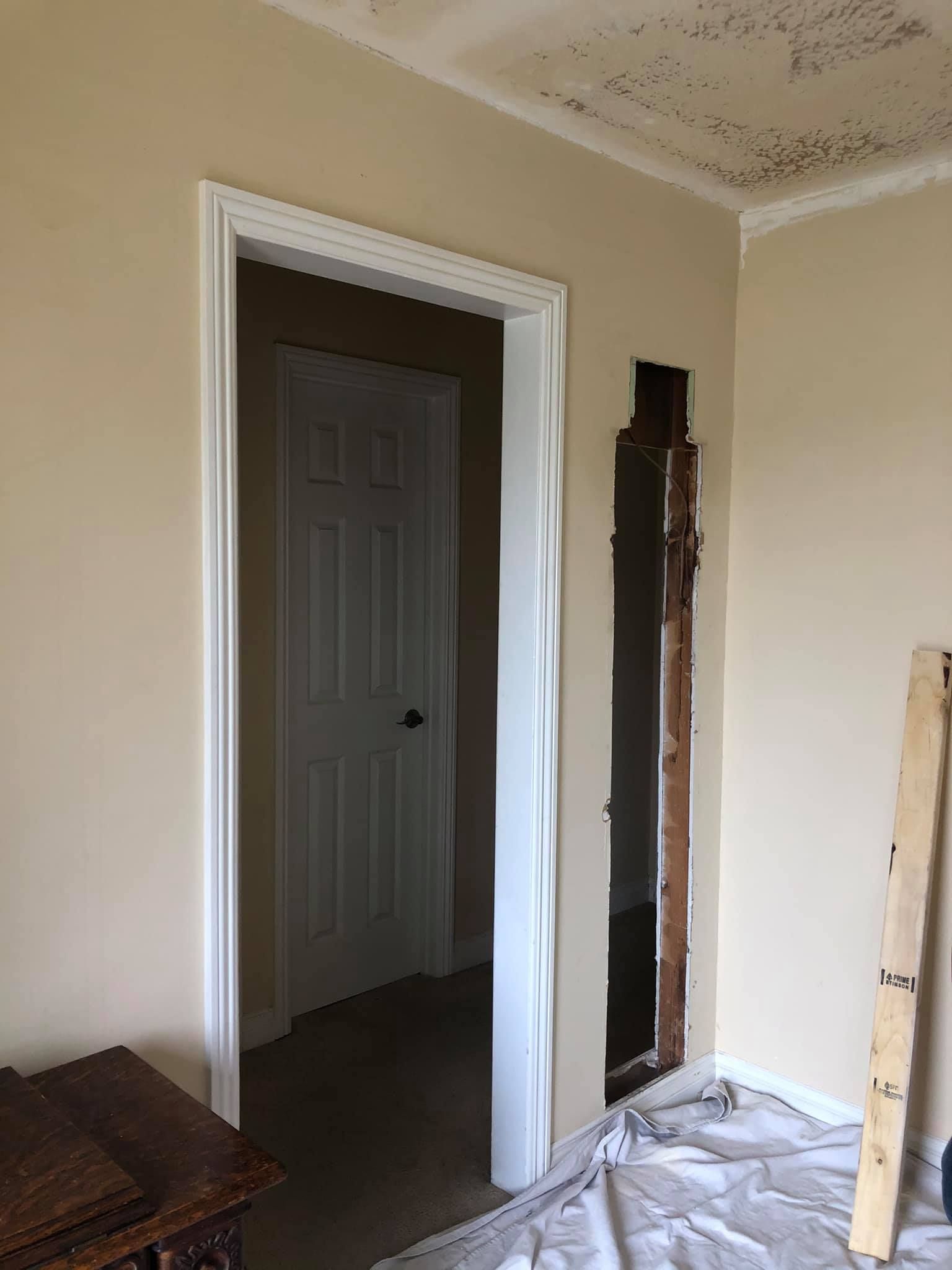 A room with a door and a hole in the wall.
