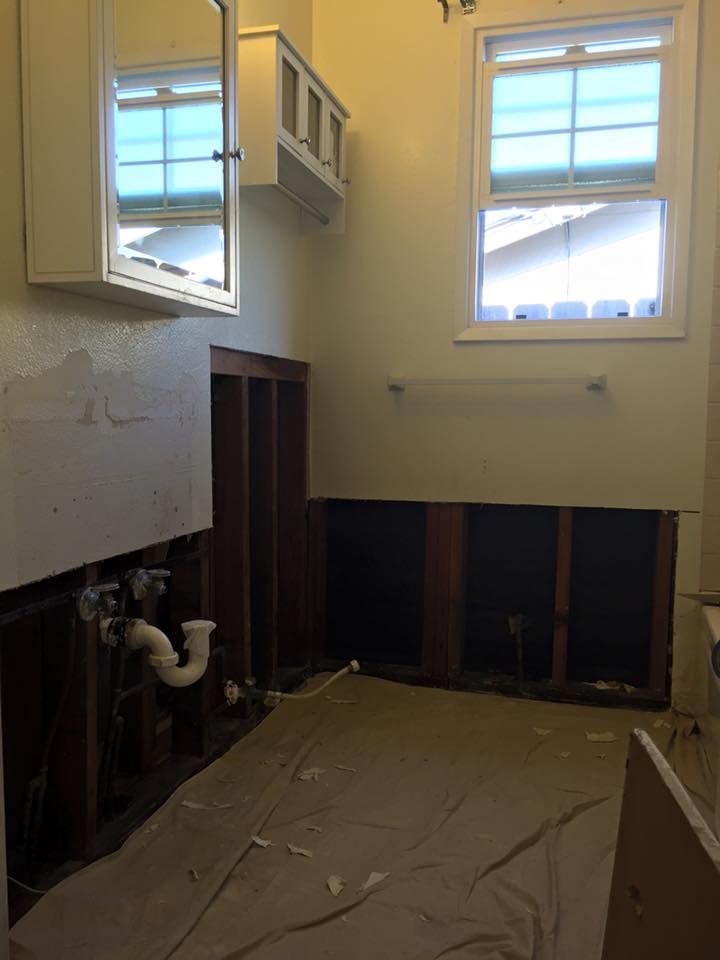 A bathroom under construction with a sink and a mirror