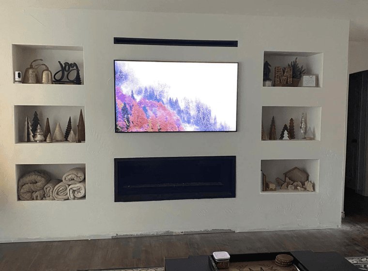 Modern home theater with gray sectional seating, blue chairs, and a large projection screen in a sleek room