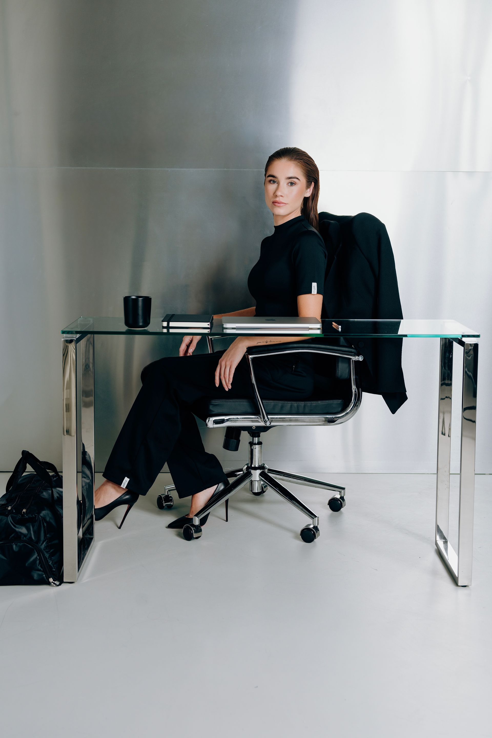 LINA SANTO campaign — professional woman in Interval Collection sitting behind the desk