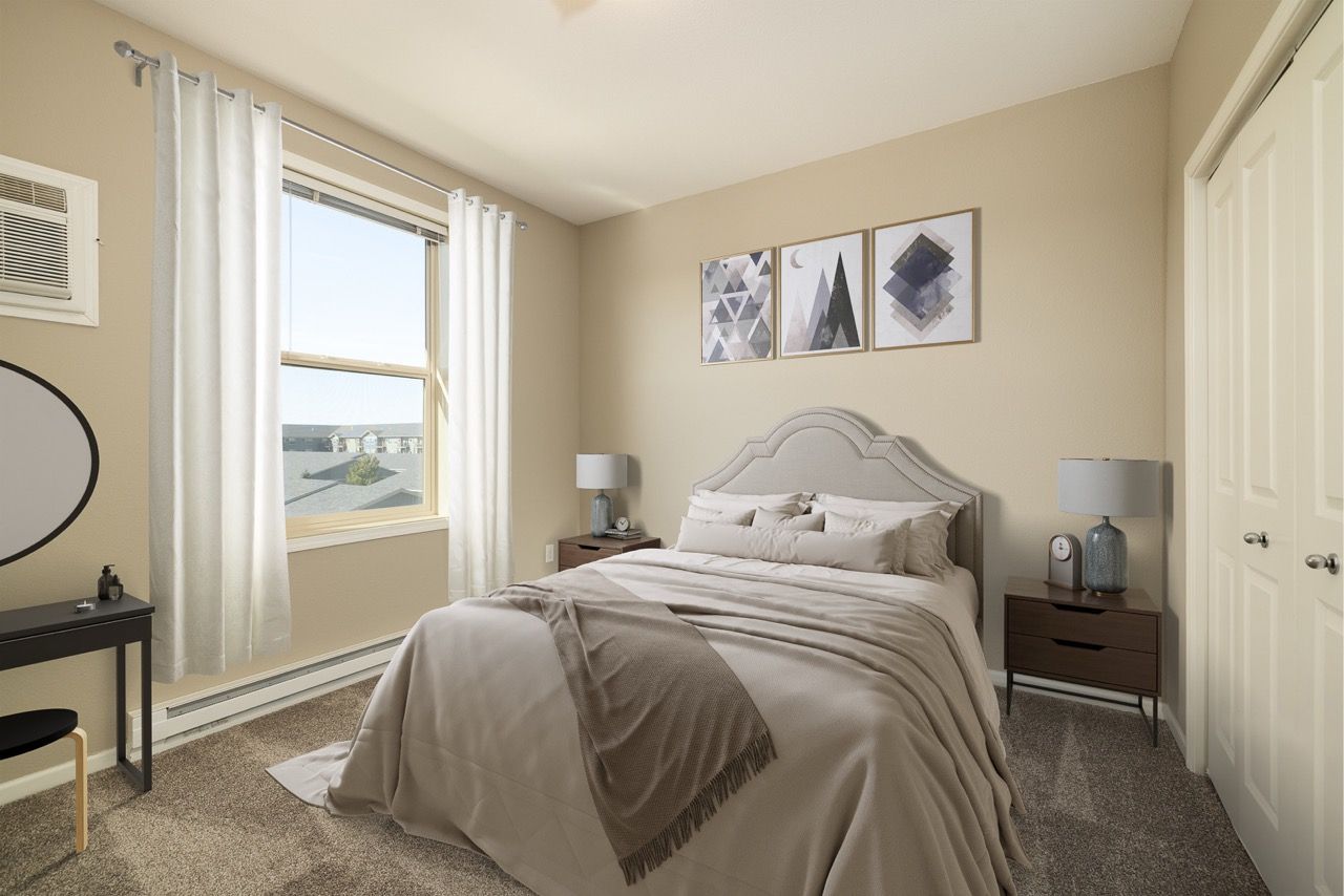 Bedroom in a modern apartment with a neutral bed, two nightstands, and a window with white curtains.