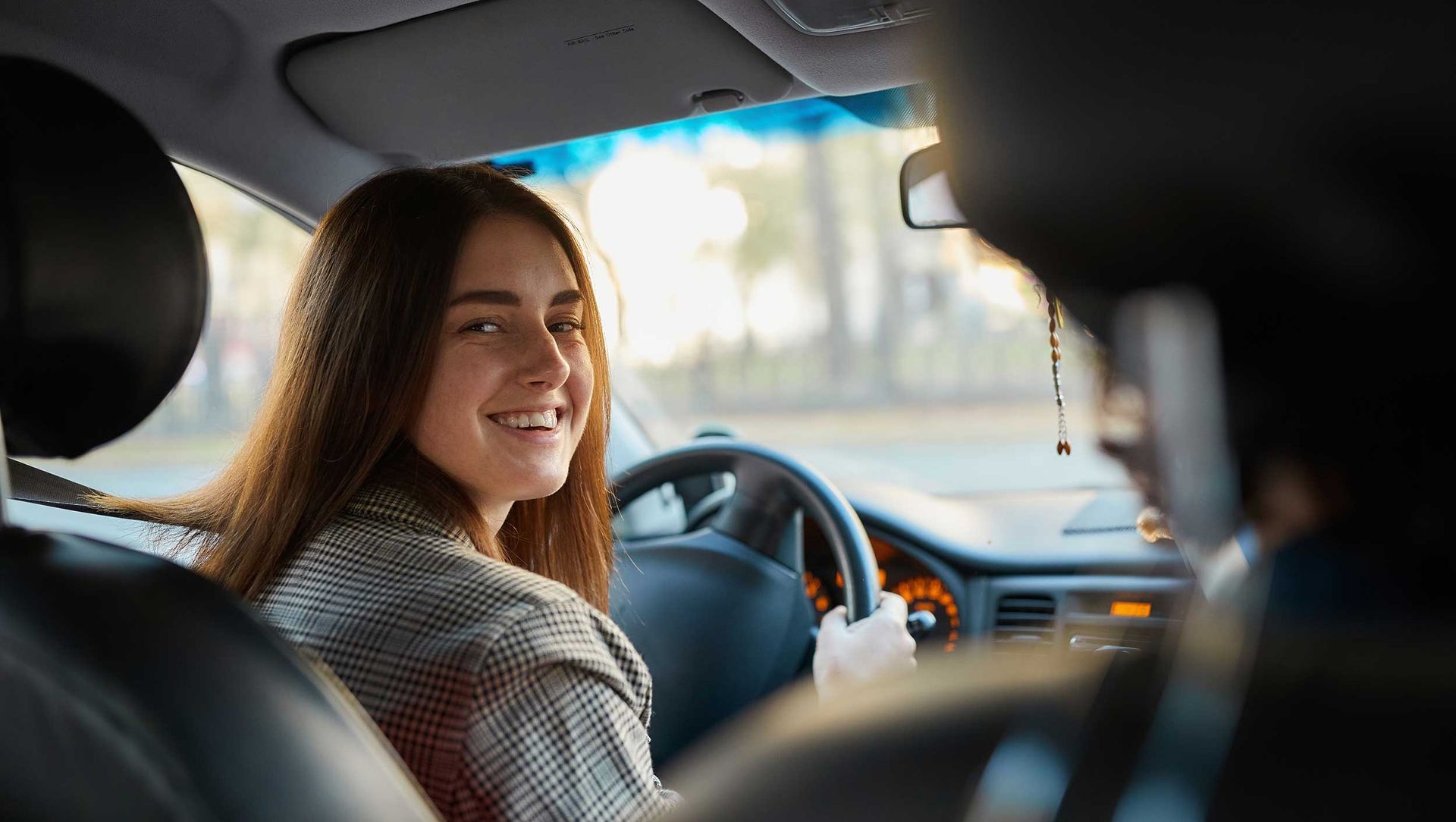 Person sitting in the driver’s seat practicing steering during a driving lesson.