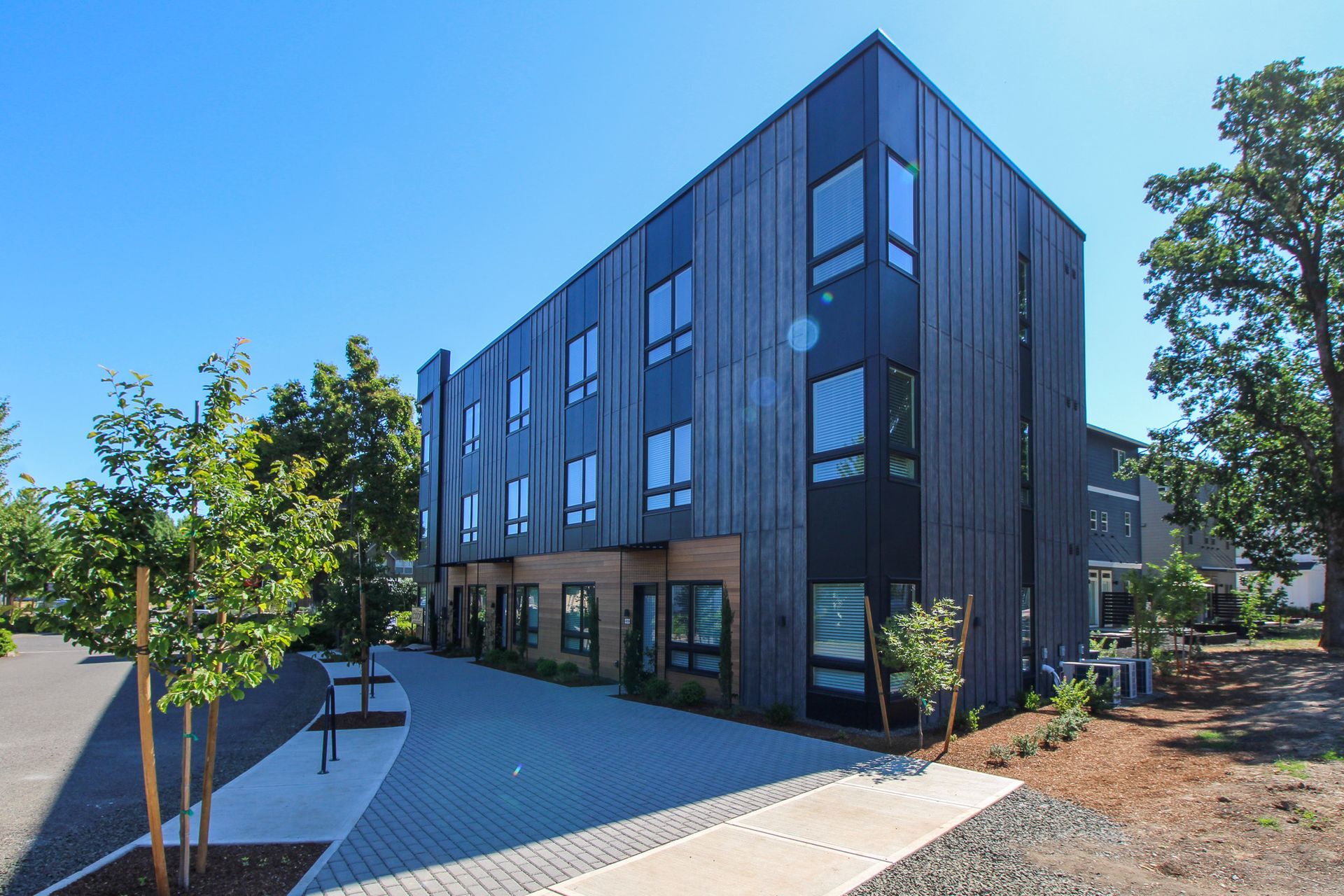 A large building with a lot of windows and trees in front of it.