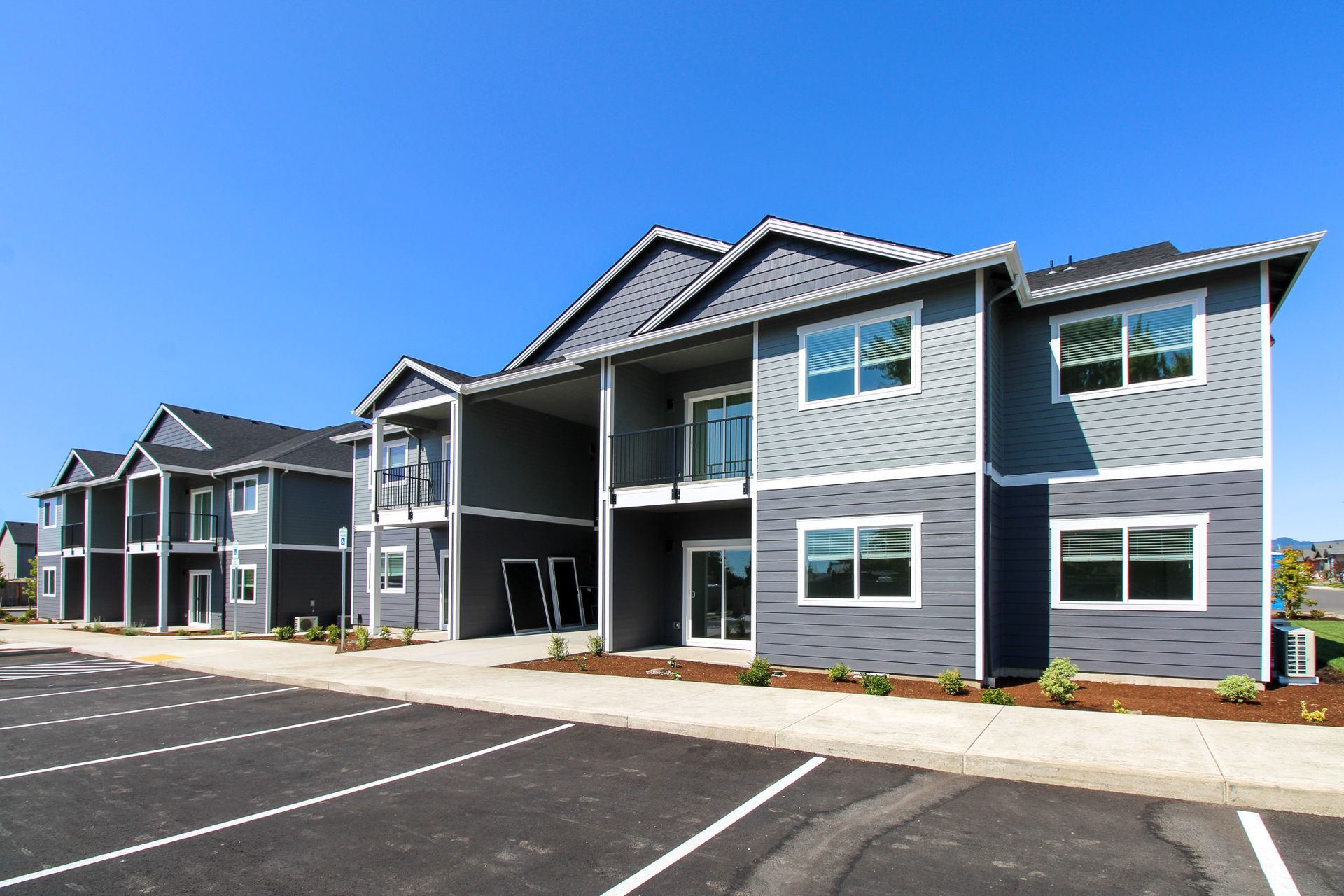 A large apartment building with a parking lot in front of it