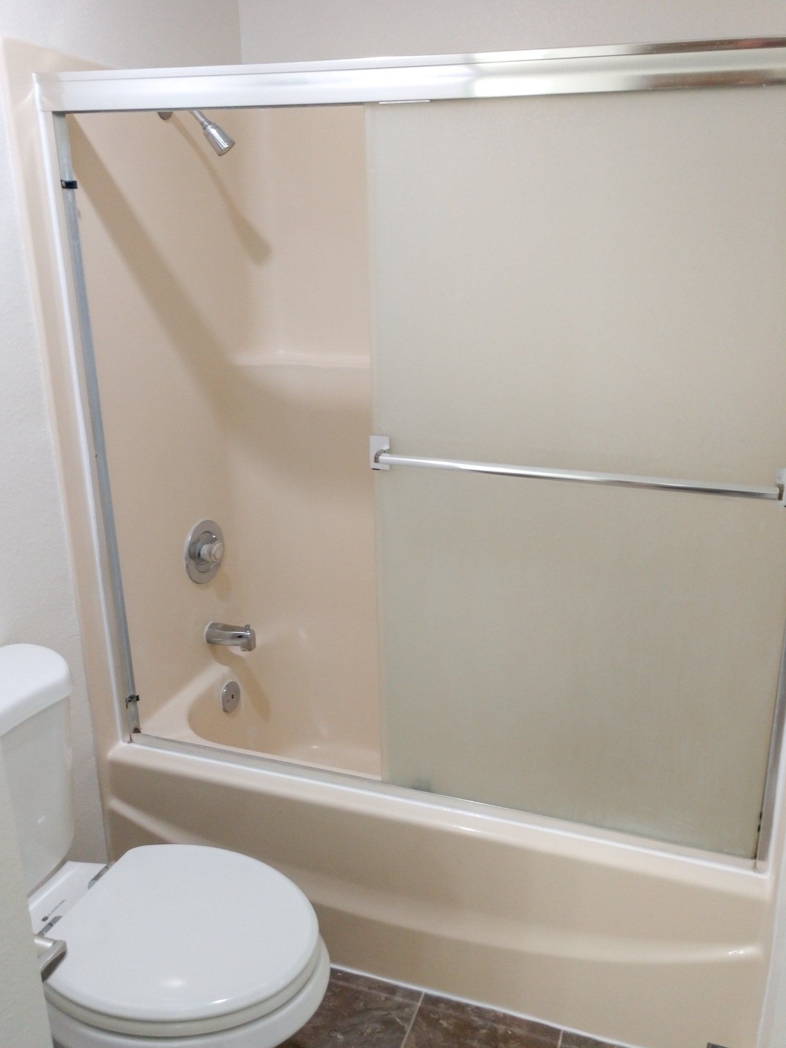 A bathroom with a toilet , bathtub and shower.