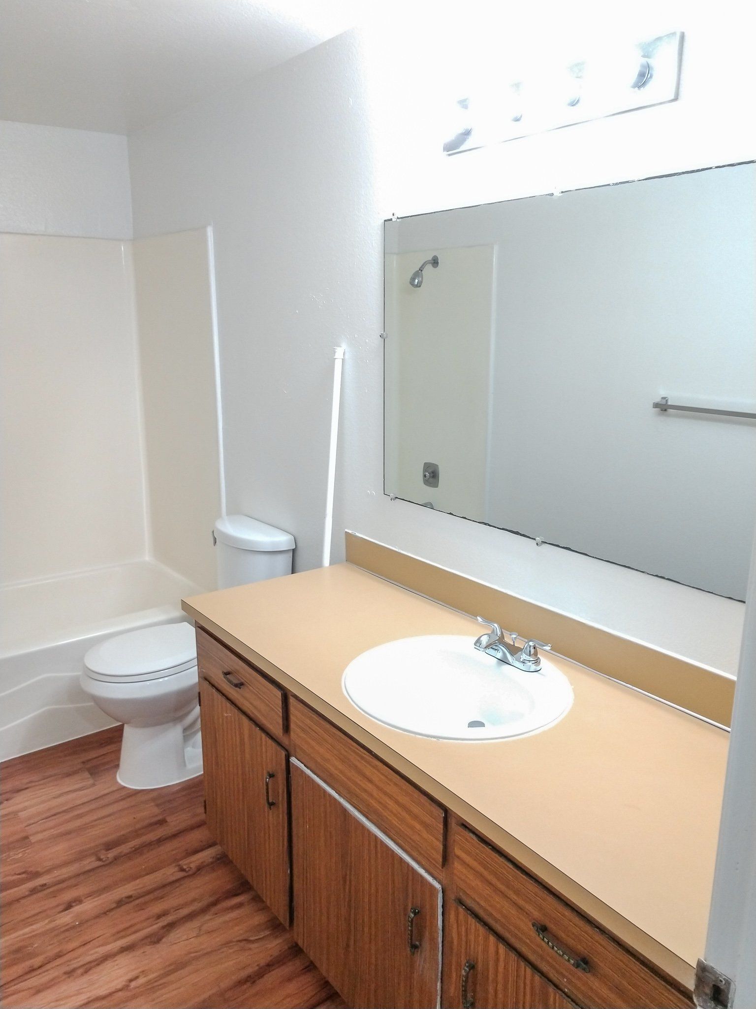 A bathroom with a toilet , sink and mirror