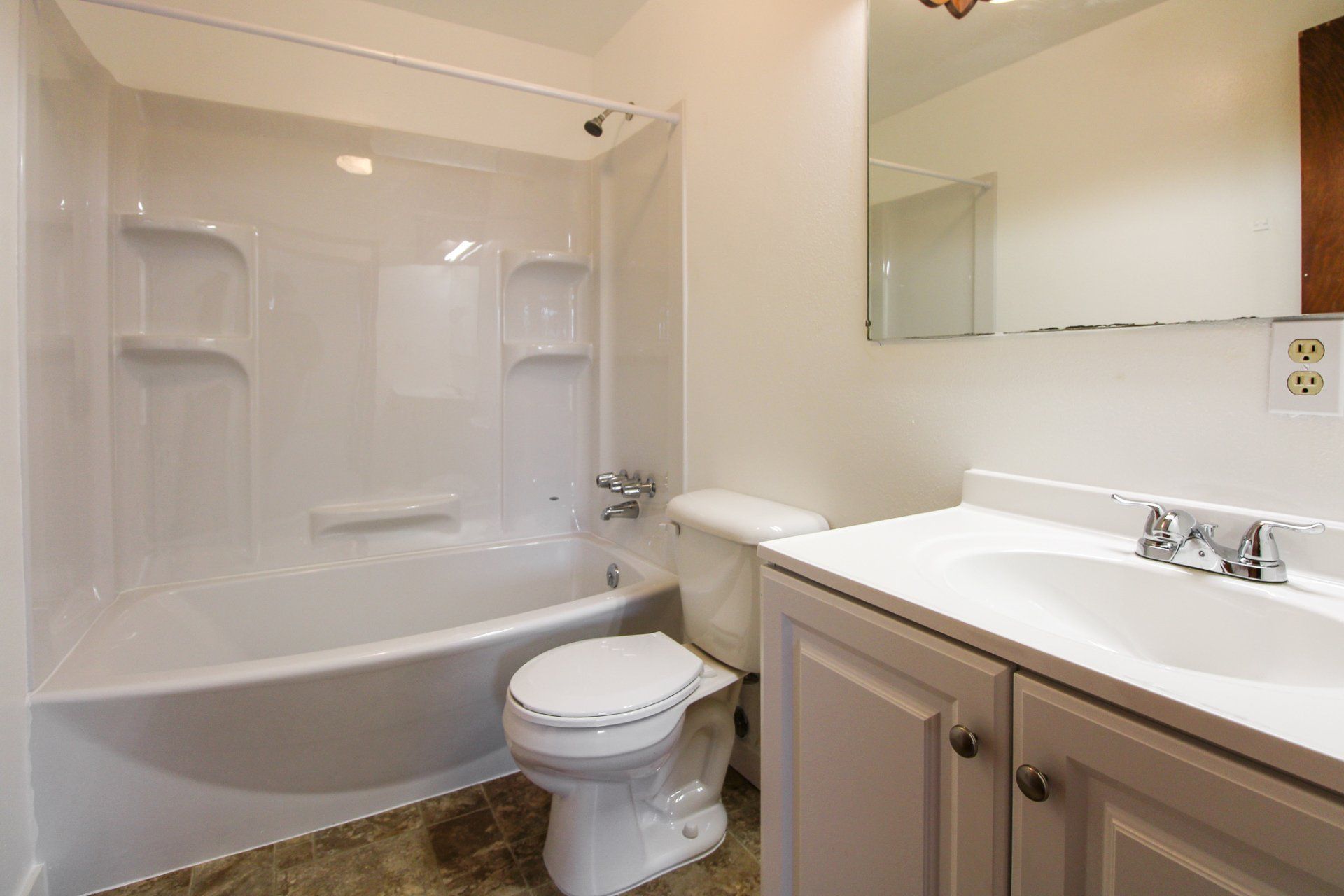 A bathroom with a toilet , sink and bathtub.