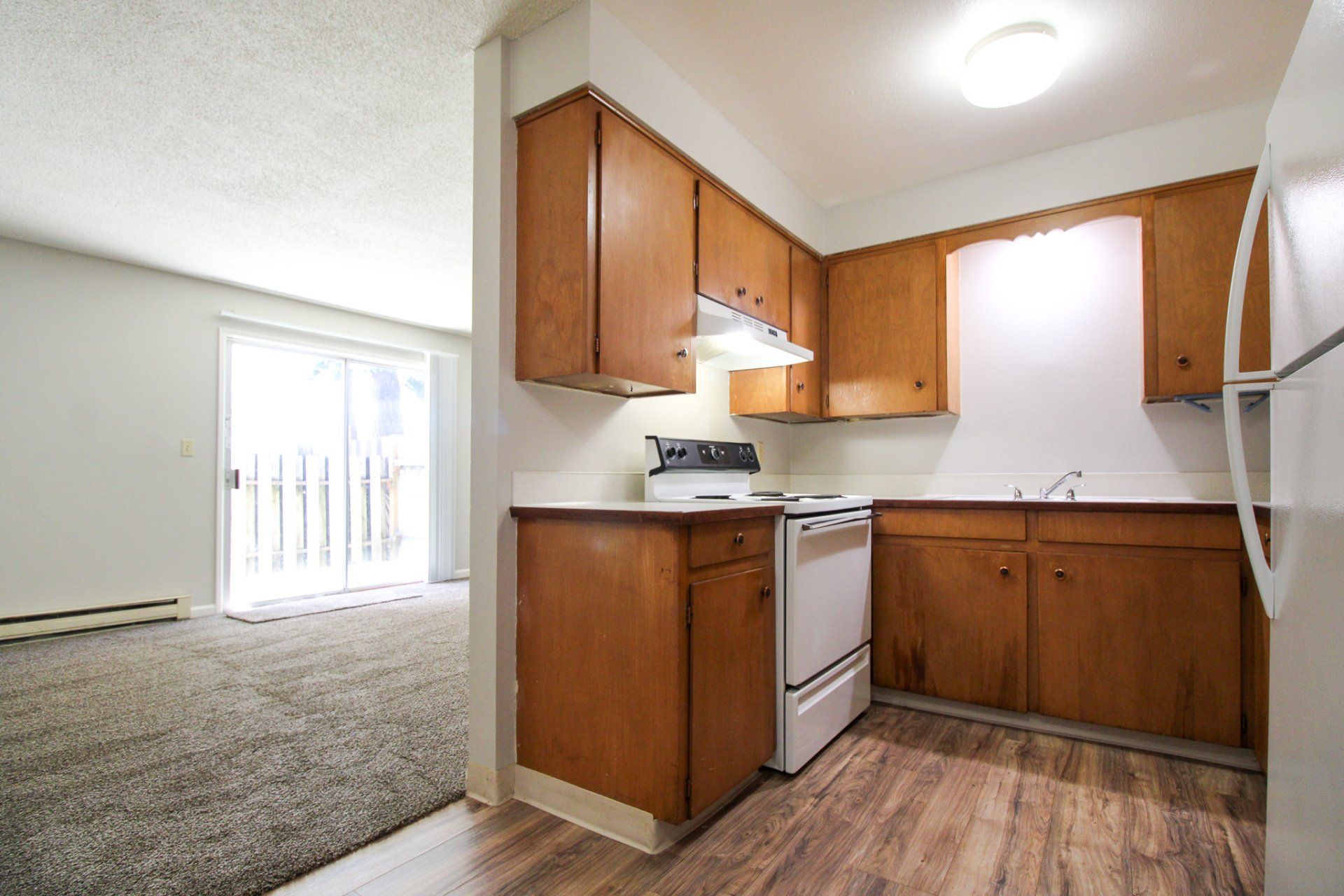 A kitchen with wooden cabinets and a white refrigerator