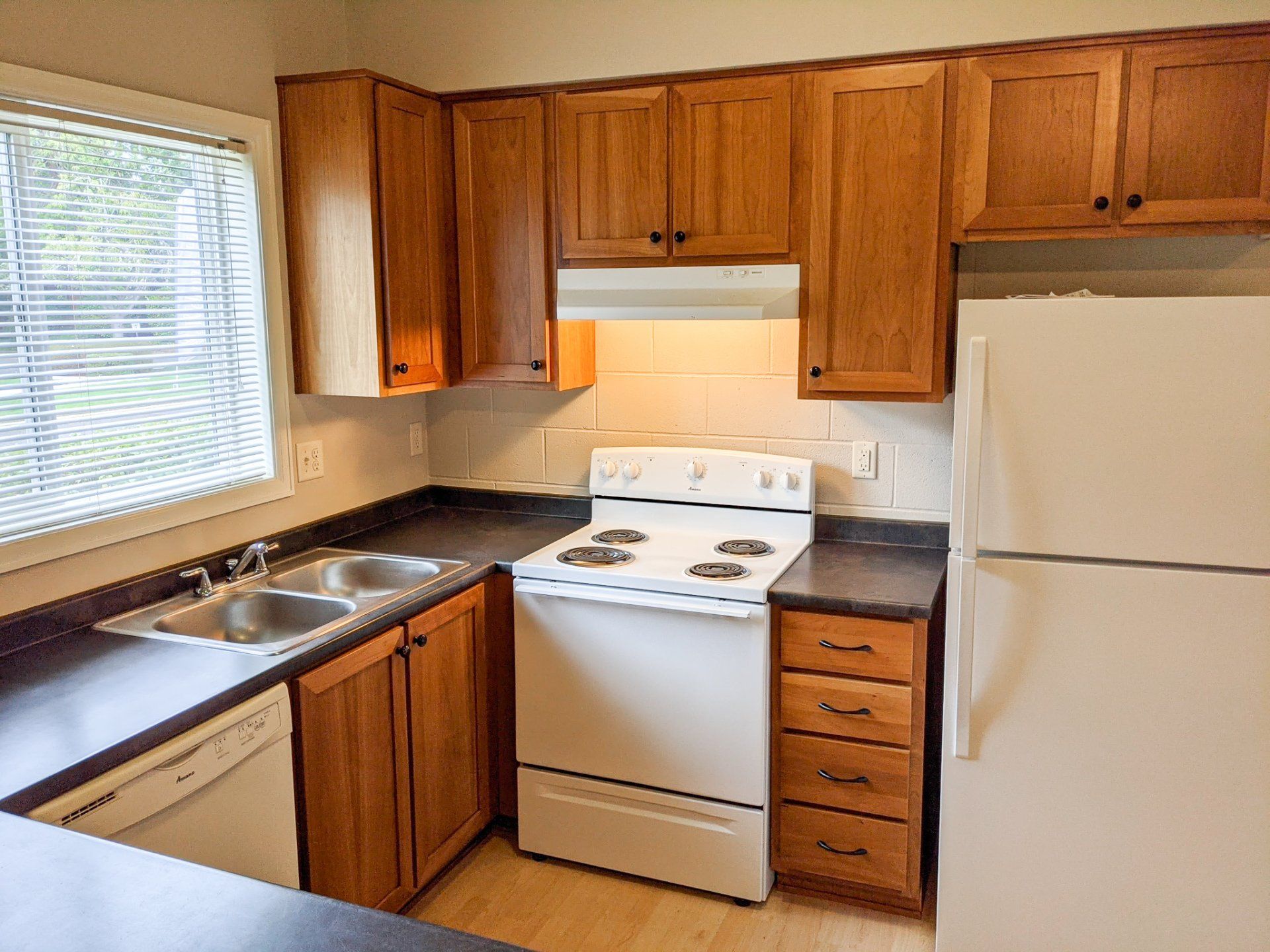 A kitchen with wooden cabinets and a white refrigerator