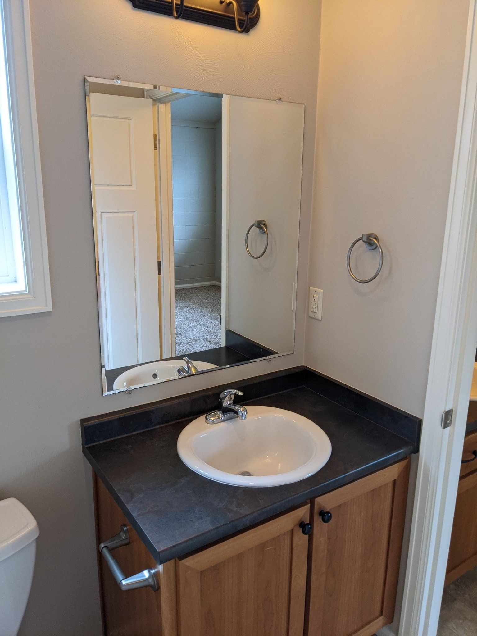 A bathroom with a sink , mirror and toilet.